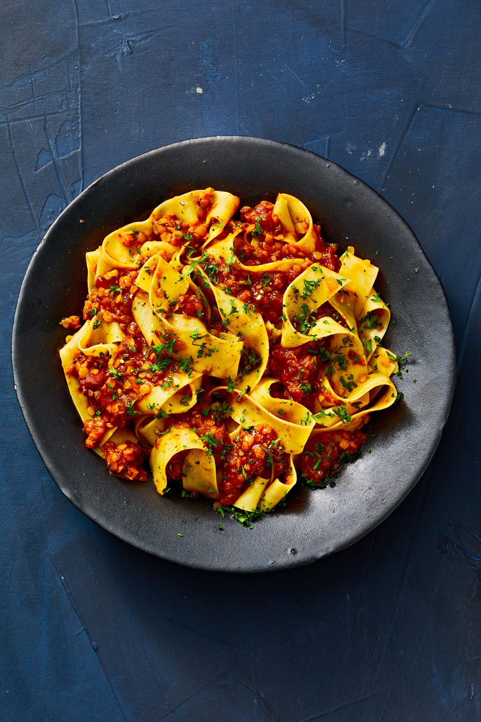 vegan bolognese on a black plate