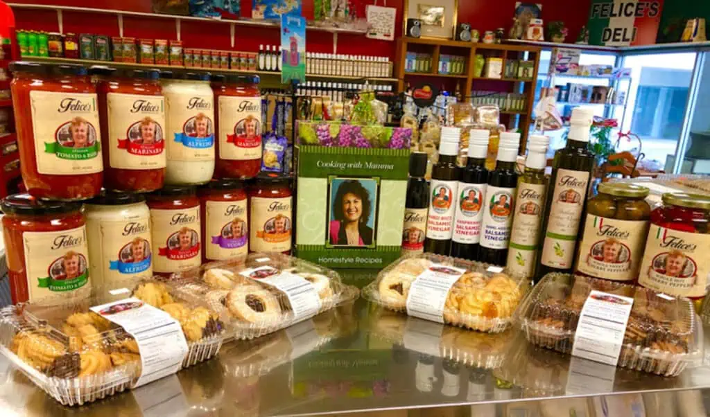A display of jarred sauces and containers of cookies.
