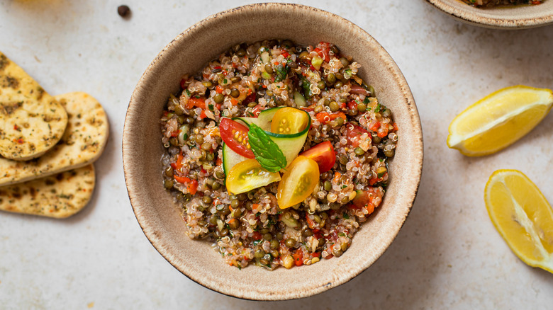 A bowl of tabbouleh with lemon wedges