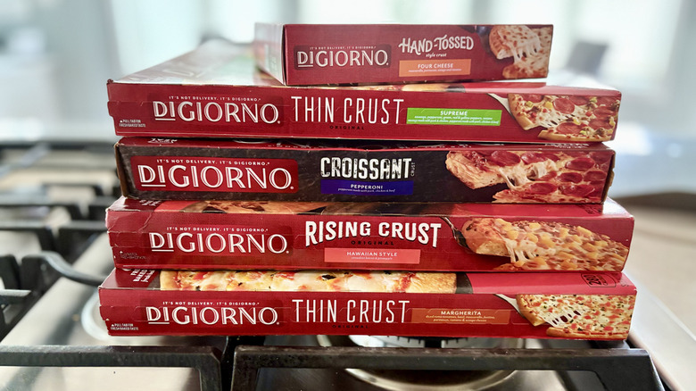 A stack of DiGiorno pizza boxes on top of an oven