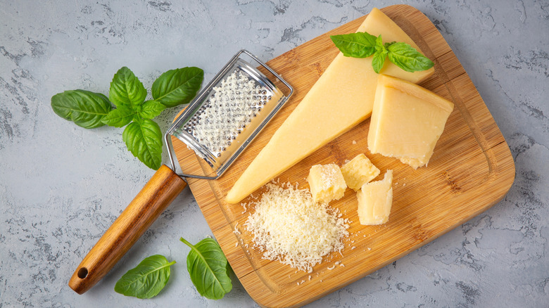 Grating Parmesan cheese on wooden cutting board