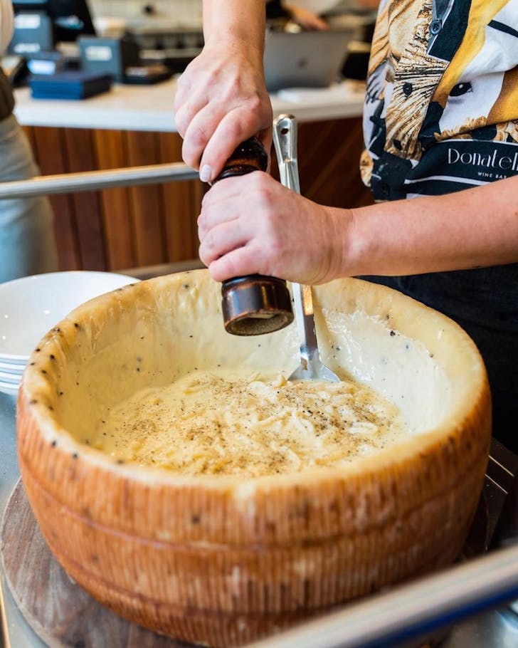 cacio e pepe in a giant cheese wheel at Tommasinos