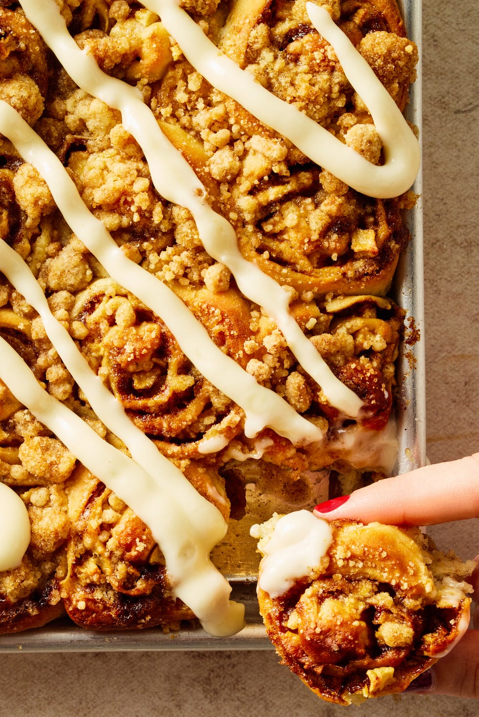 apple cinnamon roll bites on a sheet pan with icing