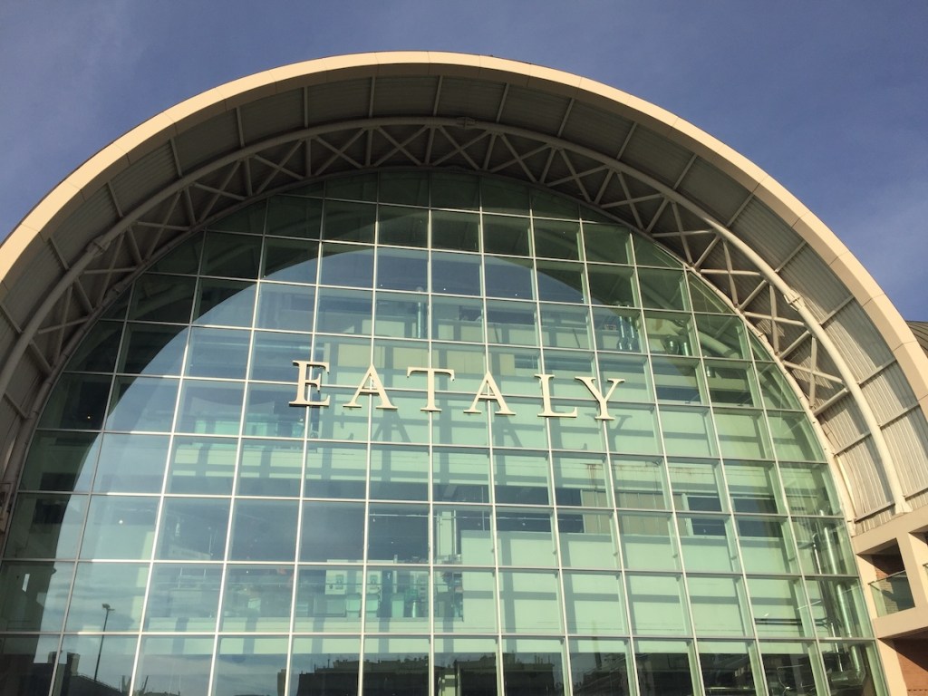 Large arch-shaped exterior of Eataly building.