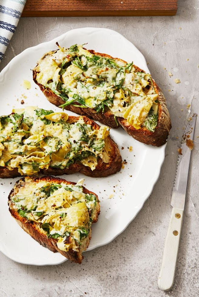 spinach artichoke tartines on a white plate