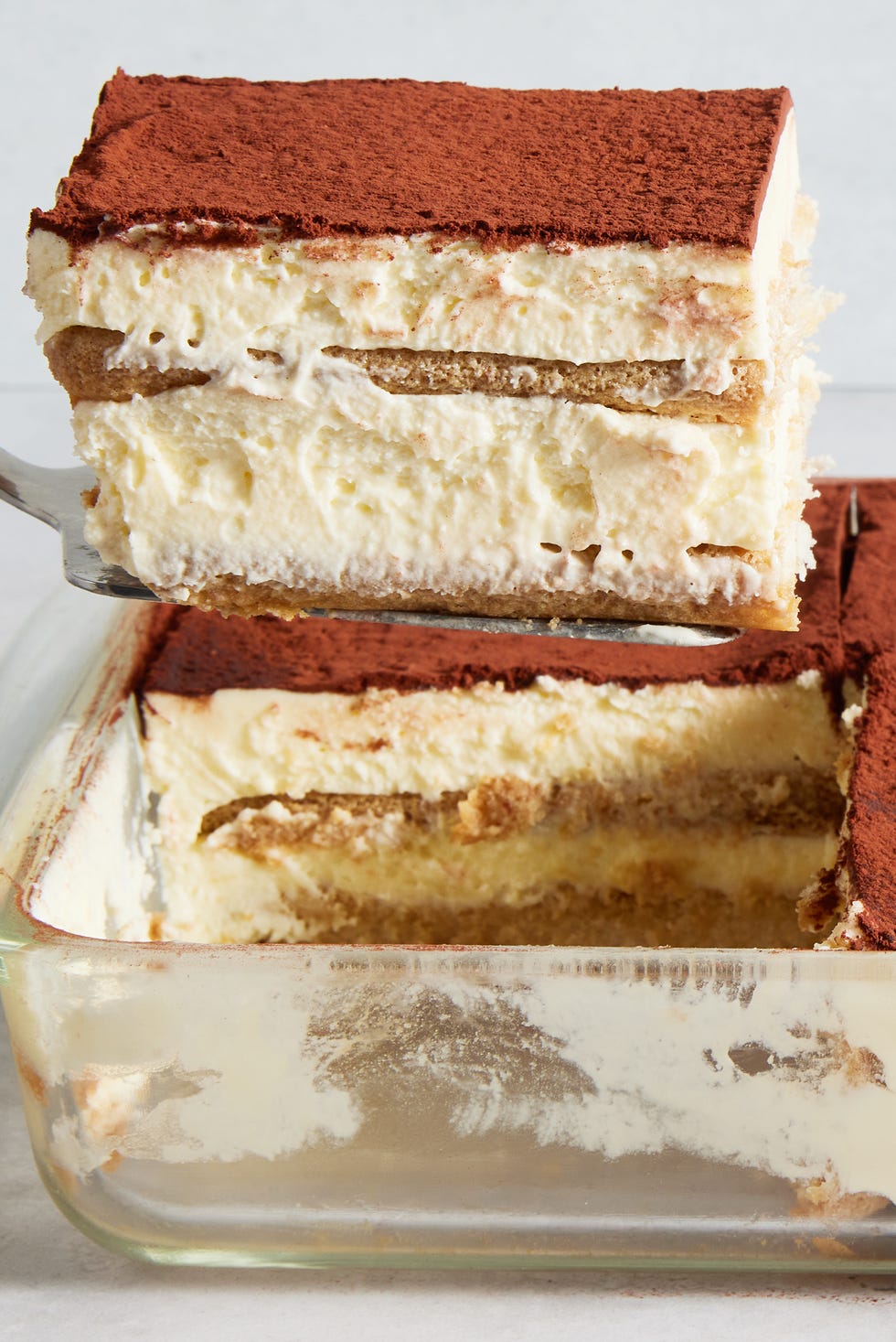 ladyfingers soaked in coffee layered with cream topped with a dusting of cocoa powder