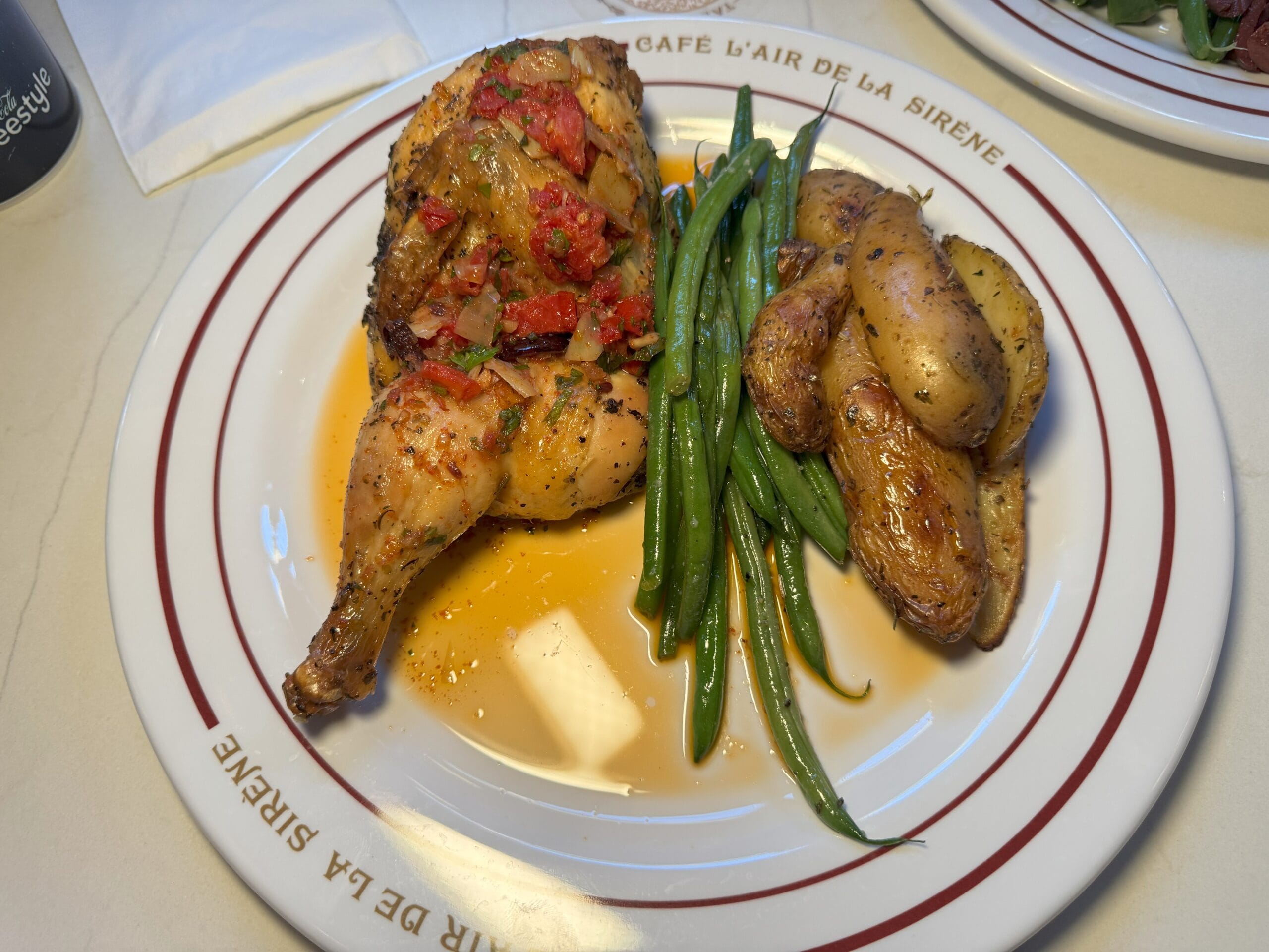 Roast chicken with herbs, green beans, and roasted fingerling potatoes at Cafe L’air de la Sirène in Epic Universe.