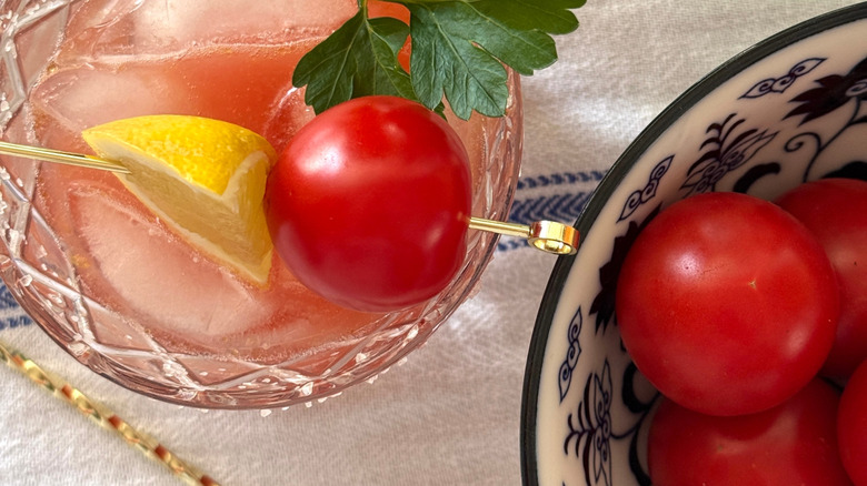 Cherry tomato as a garnish on a cocktail with lemon