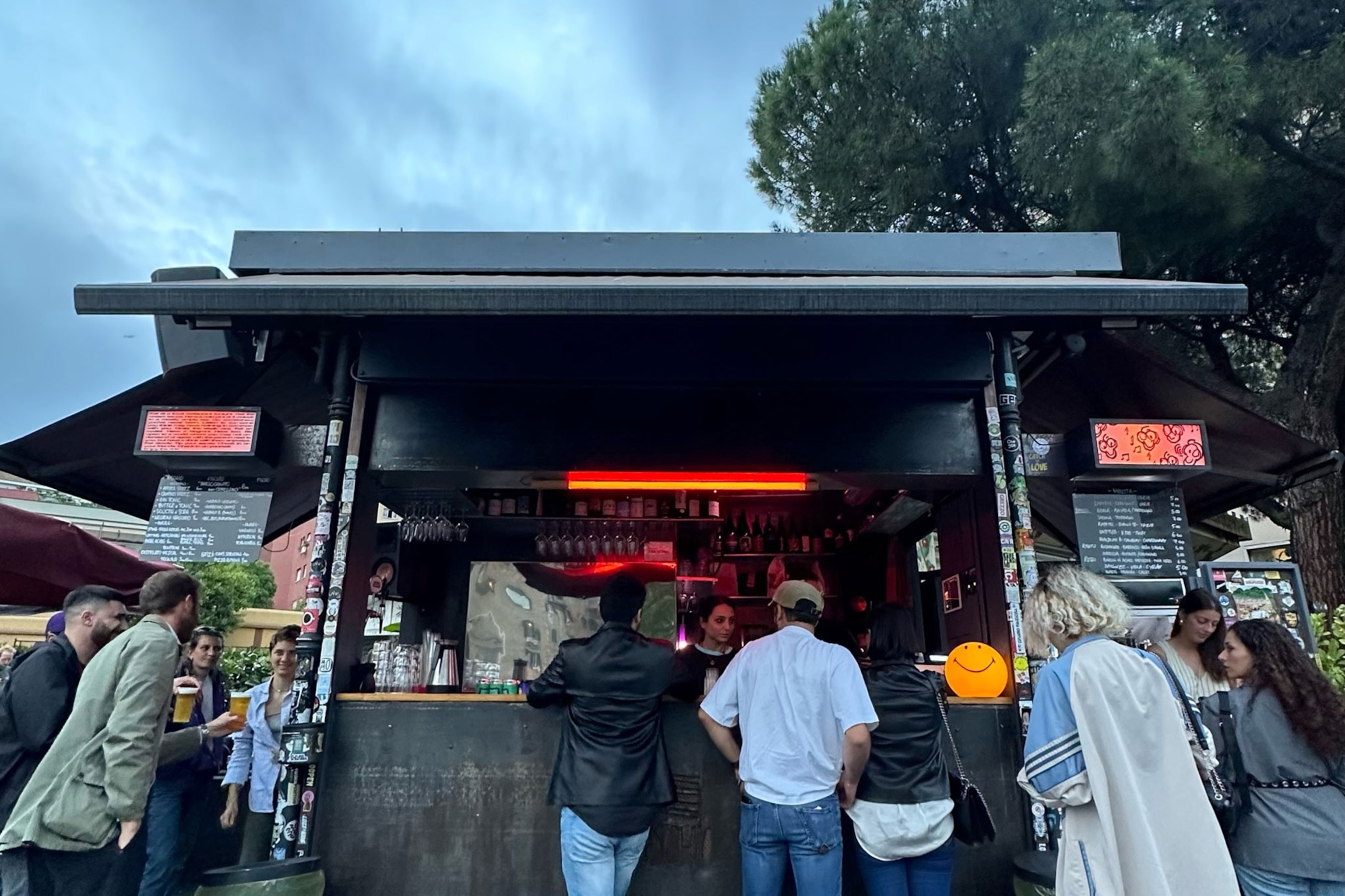 people drinking outside of the fischio kiosk in rome