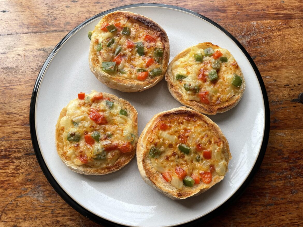 Cheese on toast with onions and red and green peppers.