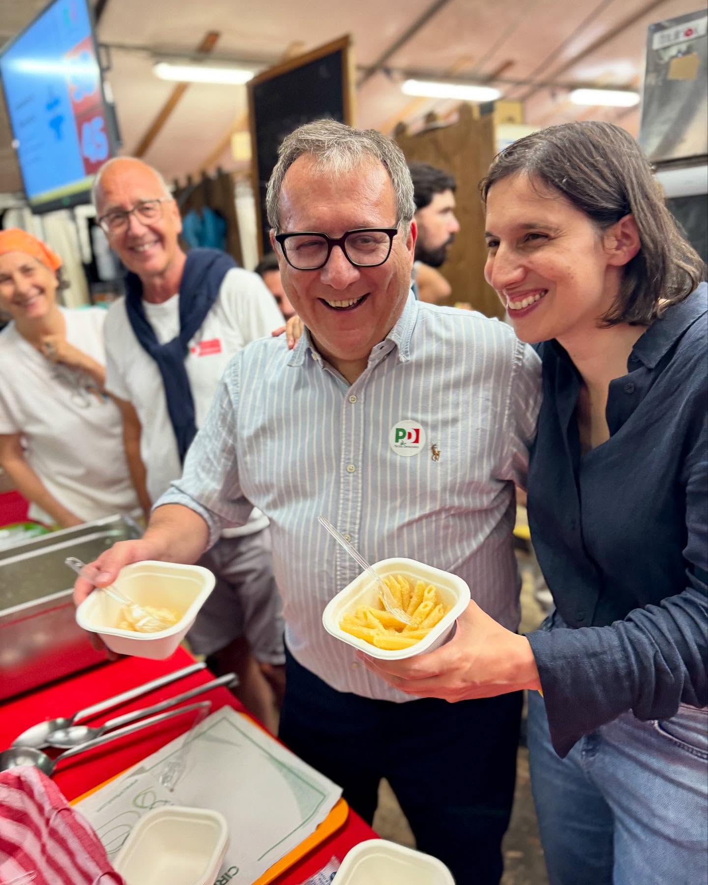 Elly Schlein and others with containers of fettuccine Alfredo.