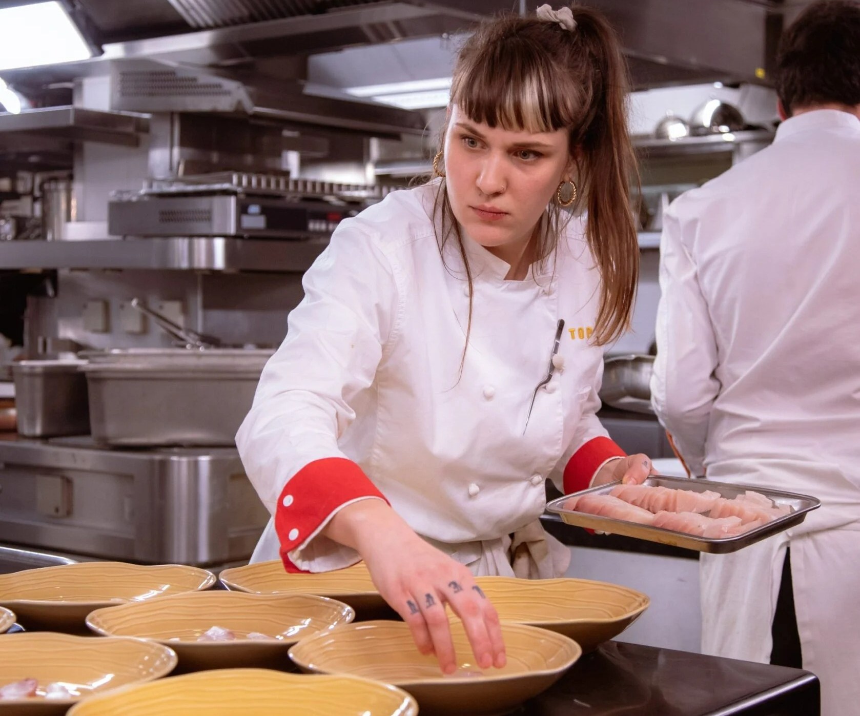 Louise Bourrat, winner of Top Chef season 13, plating food.