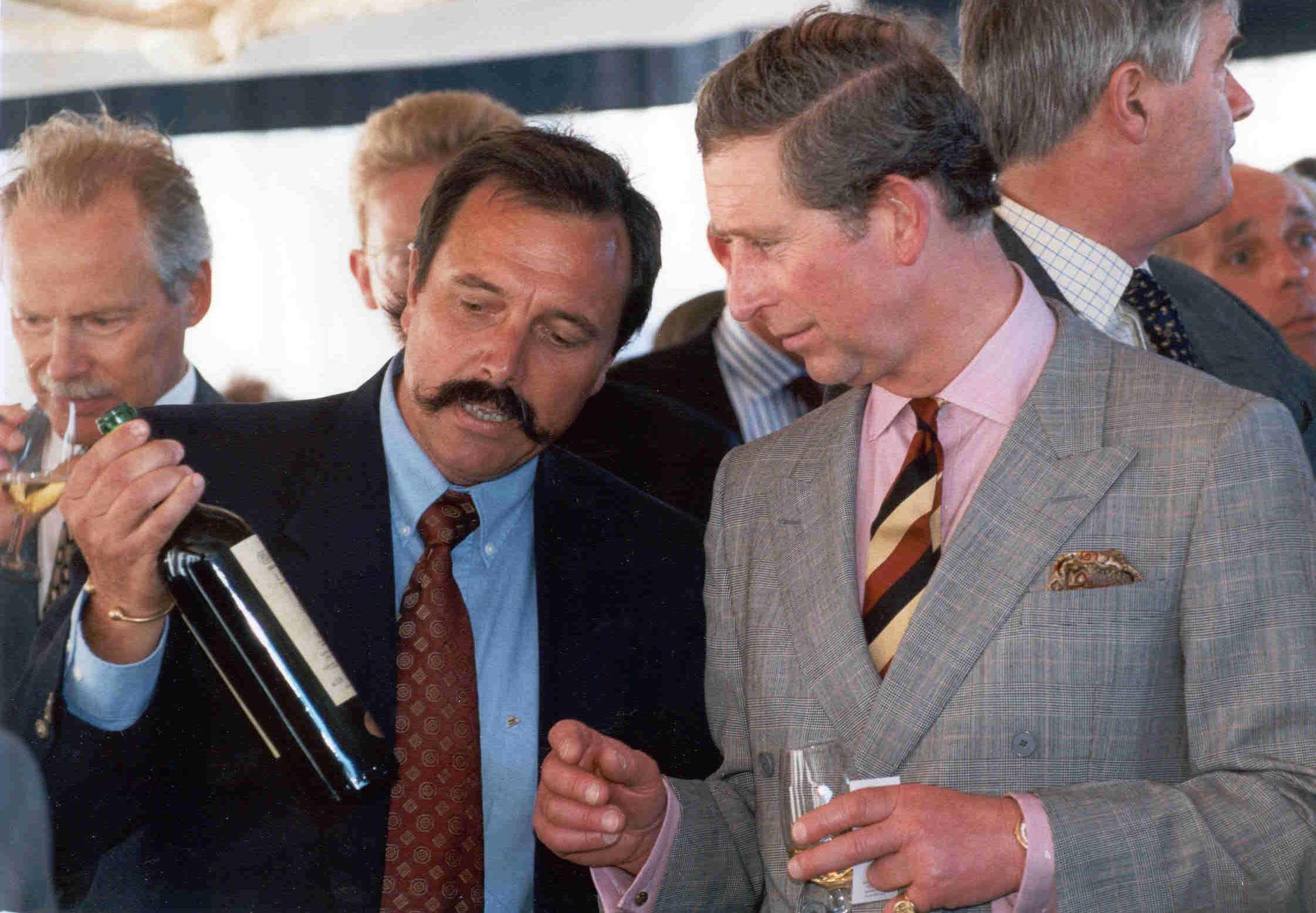 King Charles III and a man examining a bottle of wine.