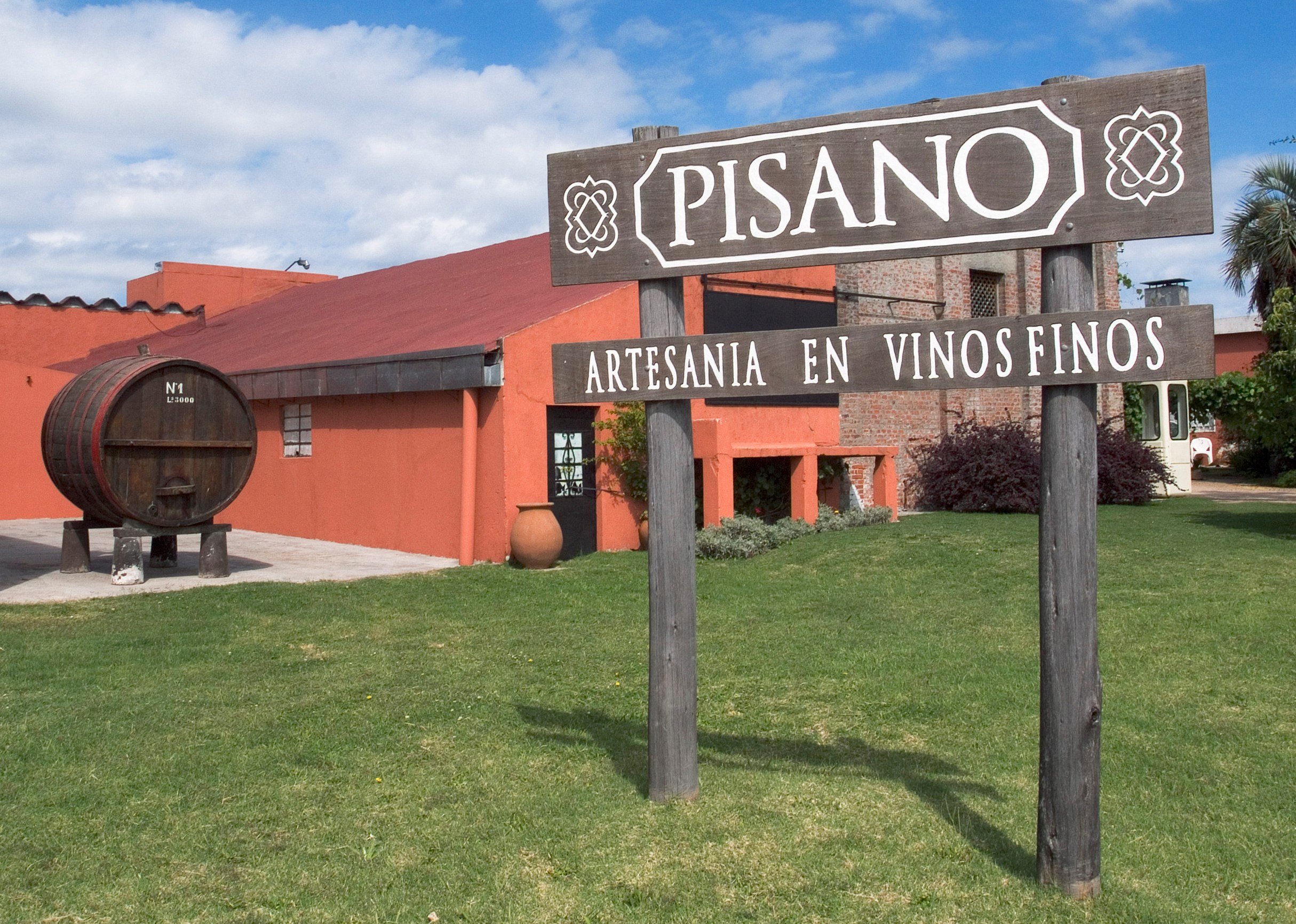 Pisano winery sign in front of building.