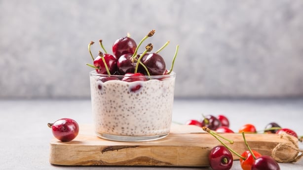Chia pudding with cherry berries, natural yogurt, in a glass on a grey surface. Selective focus. Healthy dessert, proper nutrition, super food.