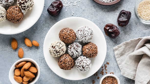 Vegan chocolate protein energy balls with dates, seeds and nuts on concrete background. Top view. Flat lay