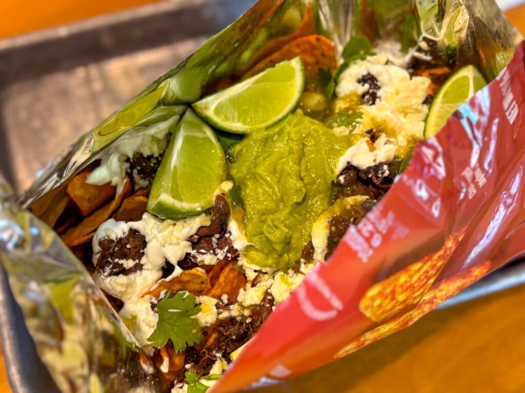 Beef Cheek Barbacoa, Oaxaca cheese, salsa verde, crema, guac, cilantro, and lime over a full size bag of Nacho Cheese Doritos 🤘🤘🤘