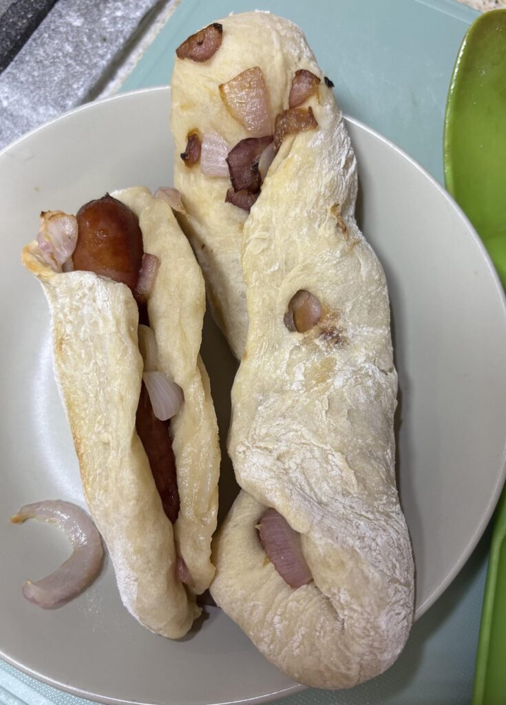 I had some leftover pizza dough and cooked some sausages and wrapped them in the dough and baked it.