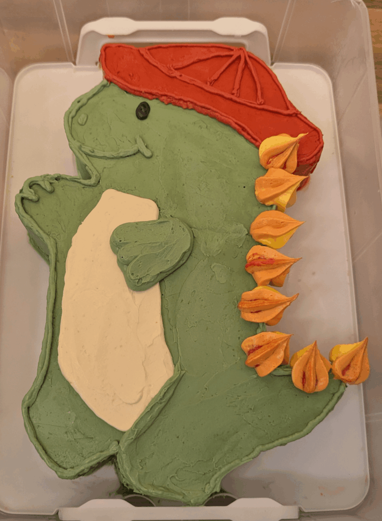 4th birthday dinosaur with firefighter hat cake