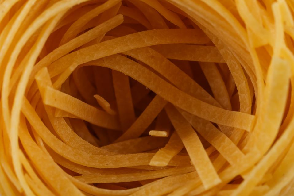 dried italian pasta, fettuccine nests, abstract food background, closeup shot