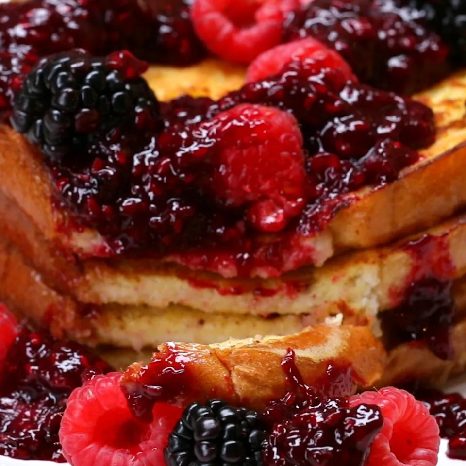 French toast topped with a mix of raspberries, blackberries, and berry sauce