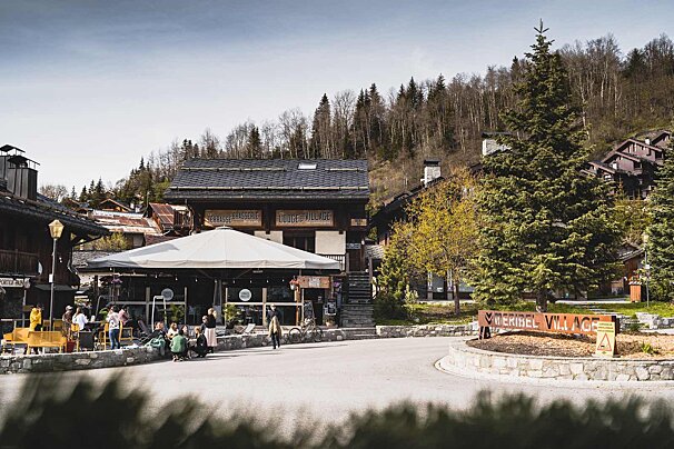 A group of people are gathered outside a restaurant with a sign that says ' montagne ' on it