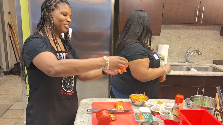 Denise Ross admires her work, chopping up a bell pepper just as she was shown by Chef Wells.