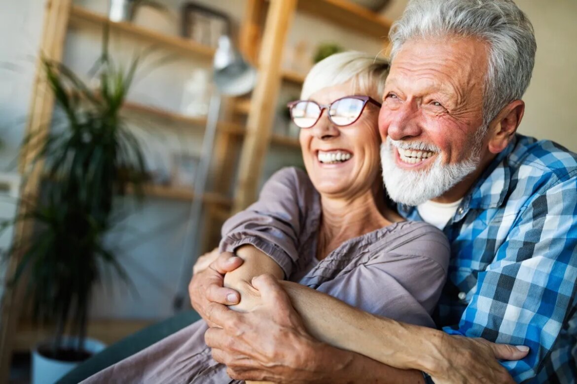 Want to Live to 100? Don’t Eat the 5 “Poisonous Ps,” Longevity Expert Says Mature husband and wife hugging and smiling at home