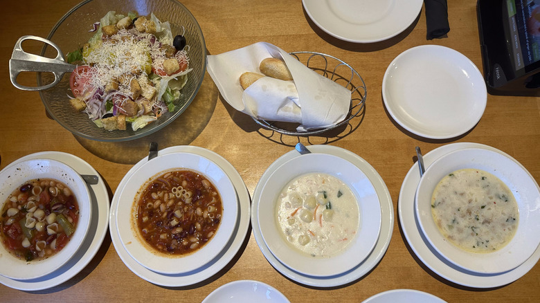 Olive Garden soup, salad, and breadsticks with white plates