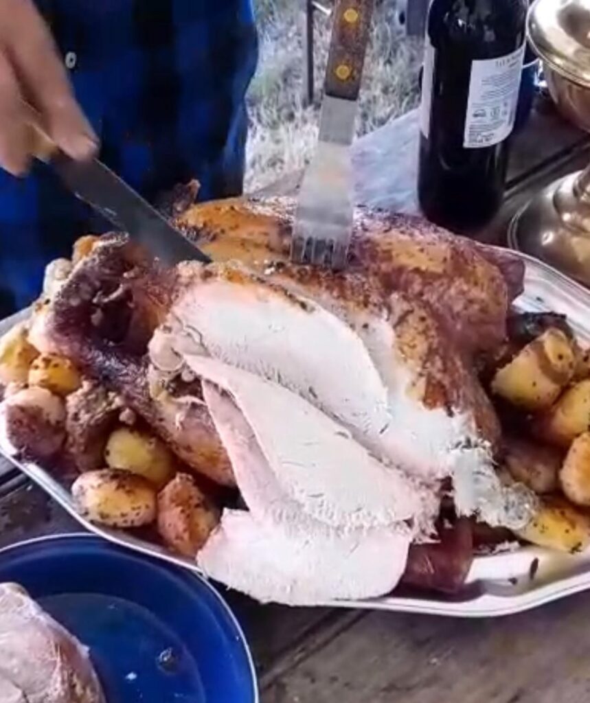 Wood-fired turkey with roast potatoes and stuffing.