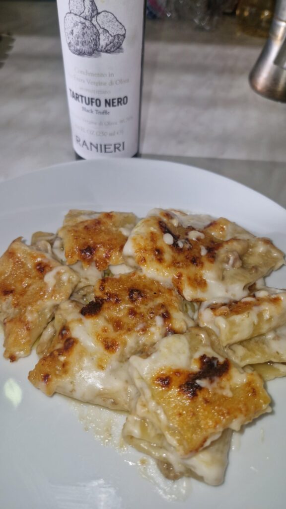 Baked paccheri with besciamella, porcini, and sausage