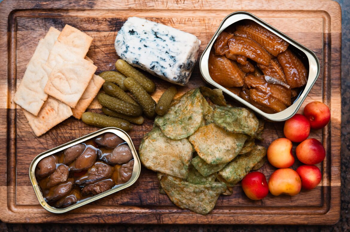 [homemade] Snack tray. Smoked oysters, HEB jalapeño kettle chips, blue cheese, garlic Parmesan pita chips, cherries glazed eel sardines and gherkins.
