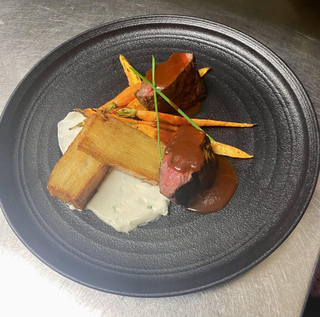 NY strip, potato pave, roasted carrots, whipped chive crème friache and a red chili Demi