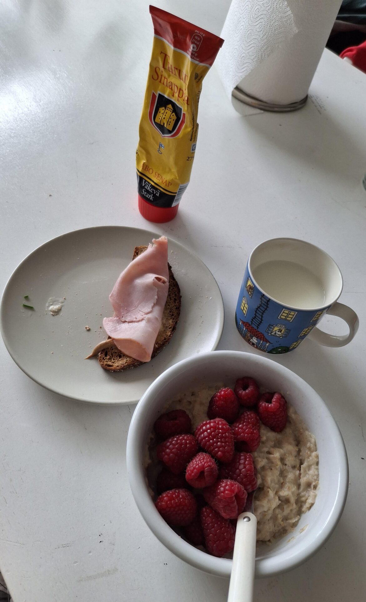 Oatmeal with fresh rasberries, Eastern-Finnish ryebread with Finnish mustard, ham and aglass of milk