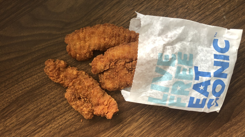 Order of three Sonic crispy chicken tenders spilling out of the bag onto a table