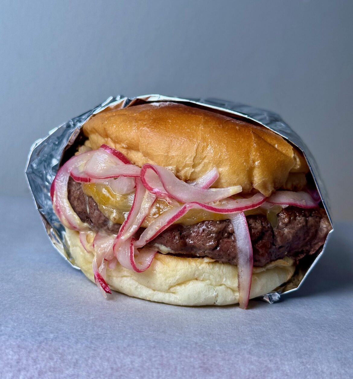 1/3lb home ground tri-tip, Japanese "butter roll" Colby Jack, pickled red onions, Dijon, ketchup.