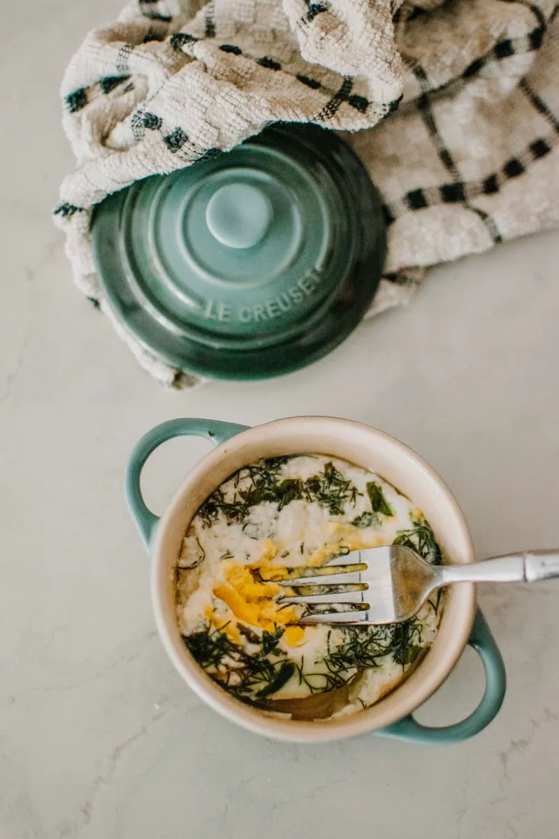 A green dutch oven with a fork inside