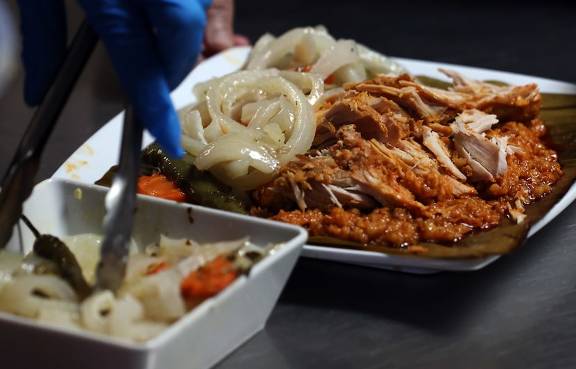 A serving of zacahuil, a huge tamal, which has a long history dating back to the Aztecs, is...