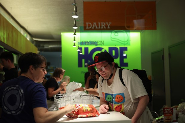 Client Brian Burke, right, gets groceries with help from a volunteer at Nourishing Hope's Sheridan Market, July 10, 2025, in Chicago. (John J. Kim/Chicago Tribune)