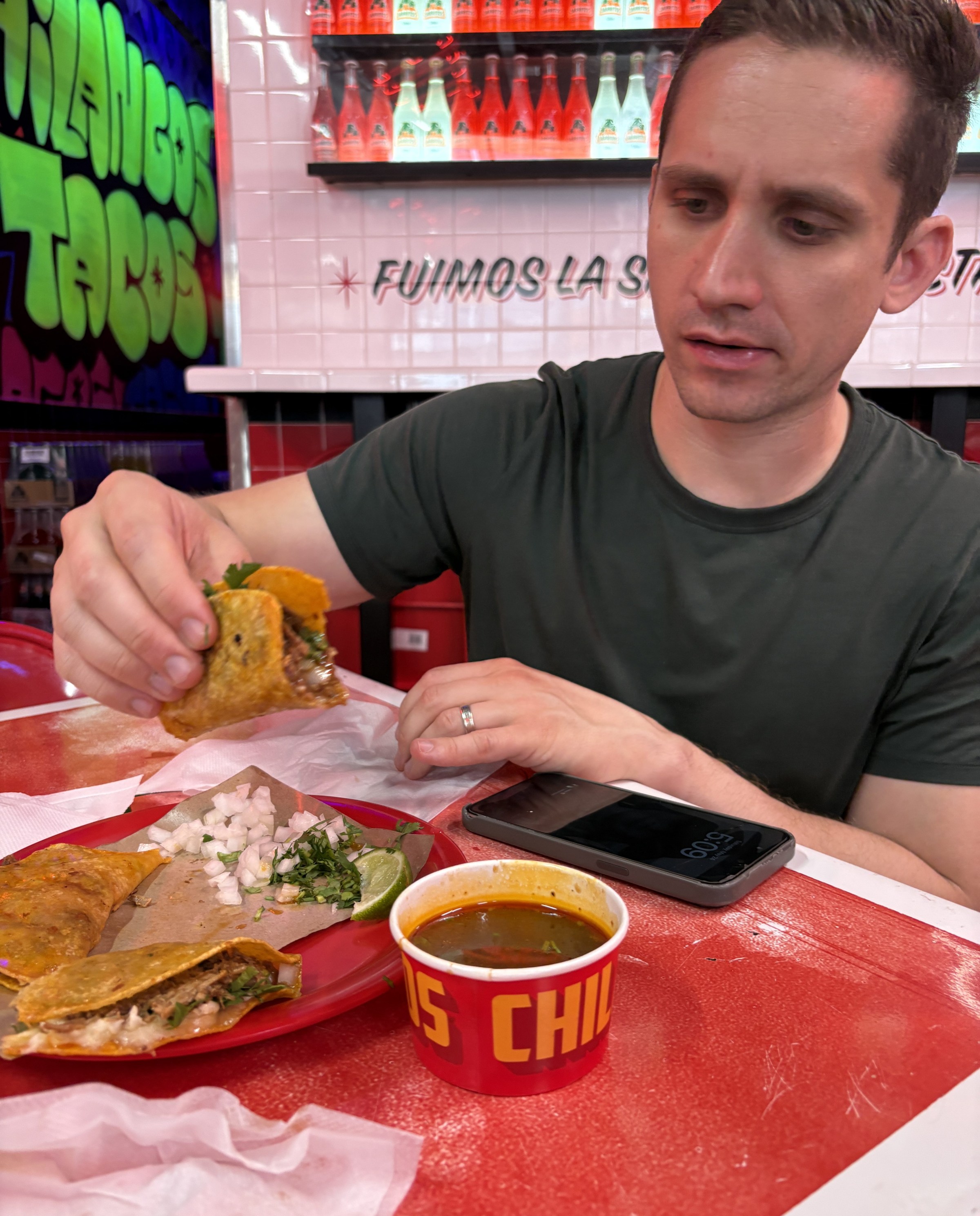 A man eats birria in a taqueria.