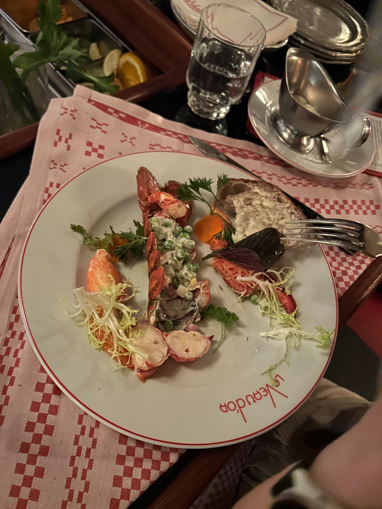 Homard macèdoine, a lobster with the meat removed from a shell that's then stuffed with a diced vegetable salad, deconstructed at Le Veau d'Or's tufted red leather bar.