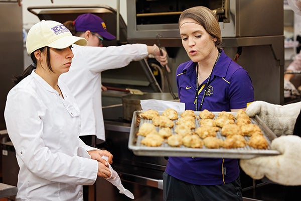 Roxanne Wilder, right, discusses food preparation techniques with nutrition sciences students in the commercial kitchen in the Rivers building.
