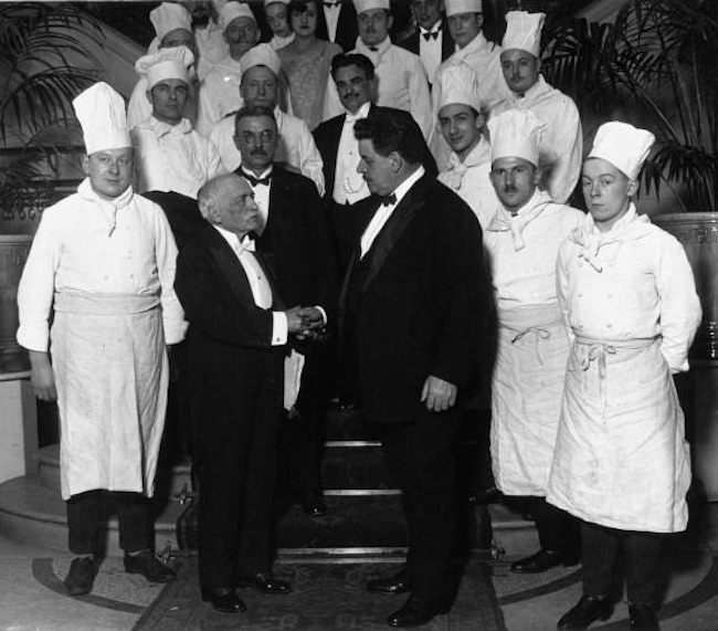 Auguste Escoffier is the smaller, besuited man, on your left. 
