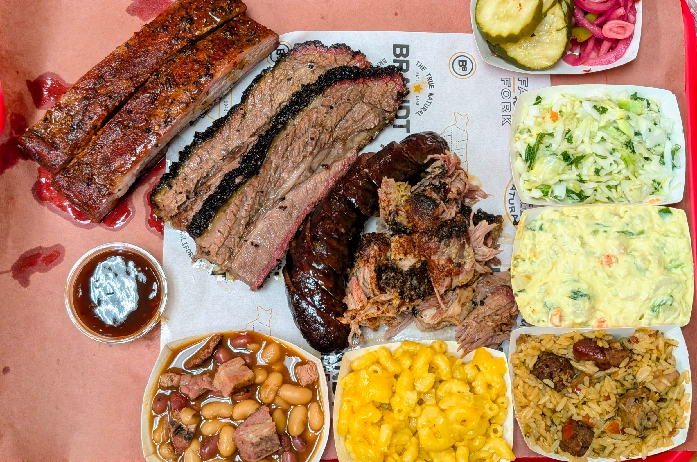 An array of smoked meats with sides.