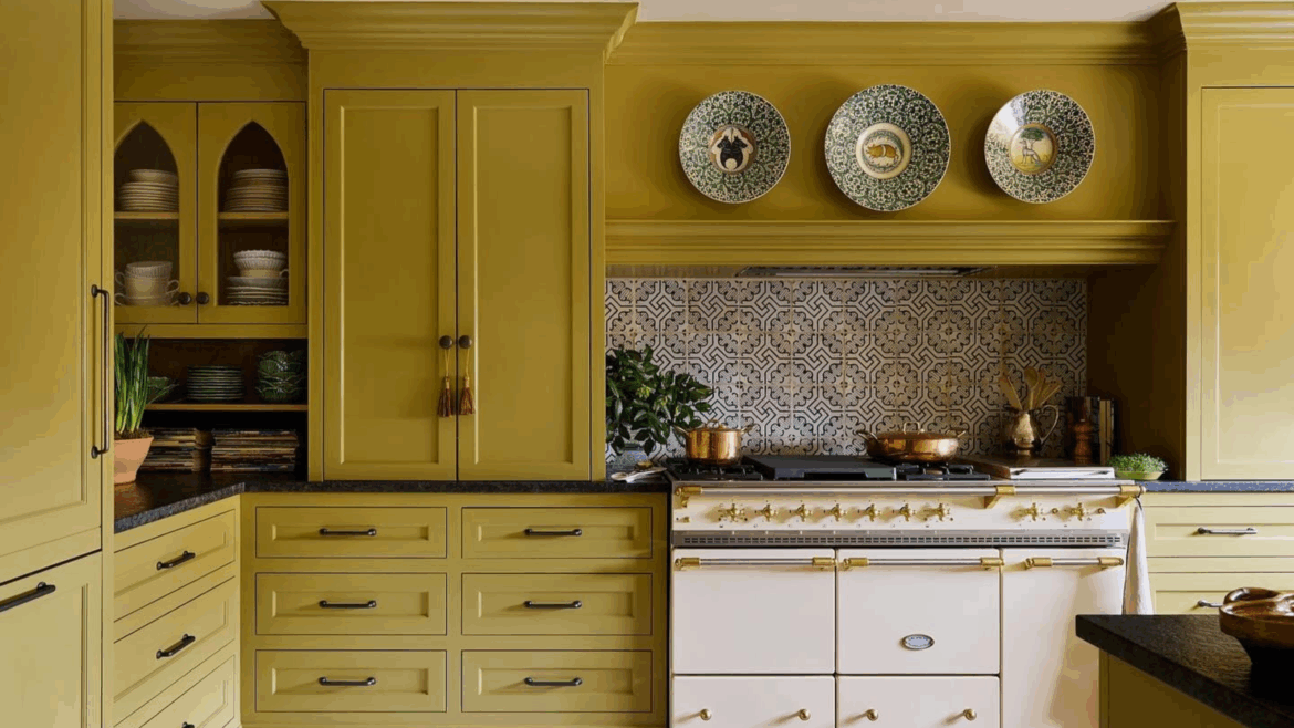 a kitchen with olive oil colored cabinetry, a butter yellow stove, black countertops, and a decorative backsplash. Above the stove hangs three decorative plates