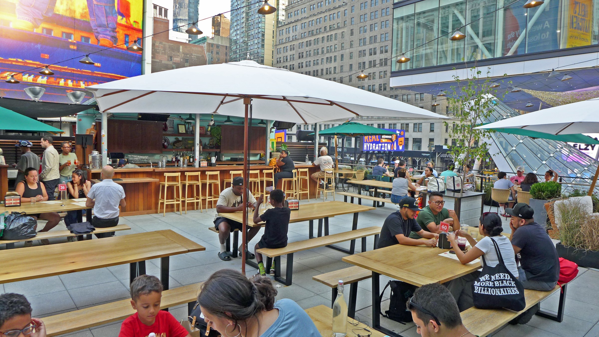 A deck with umbrellas surrounded by buildings.