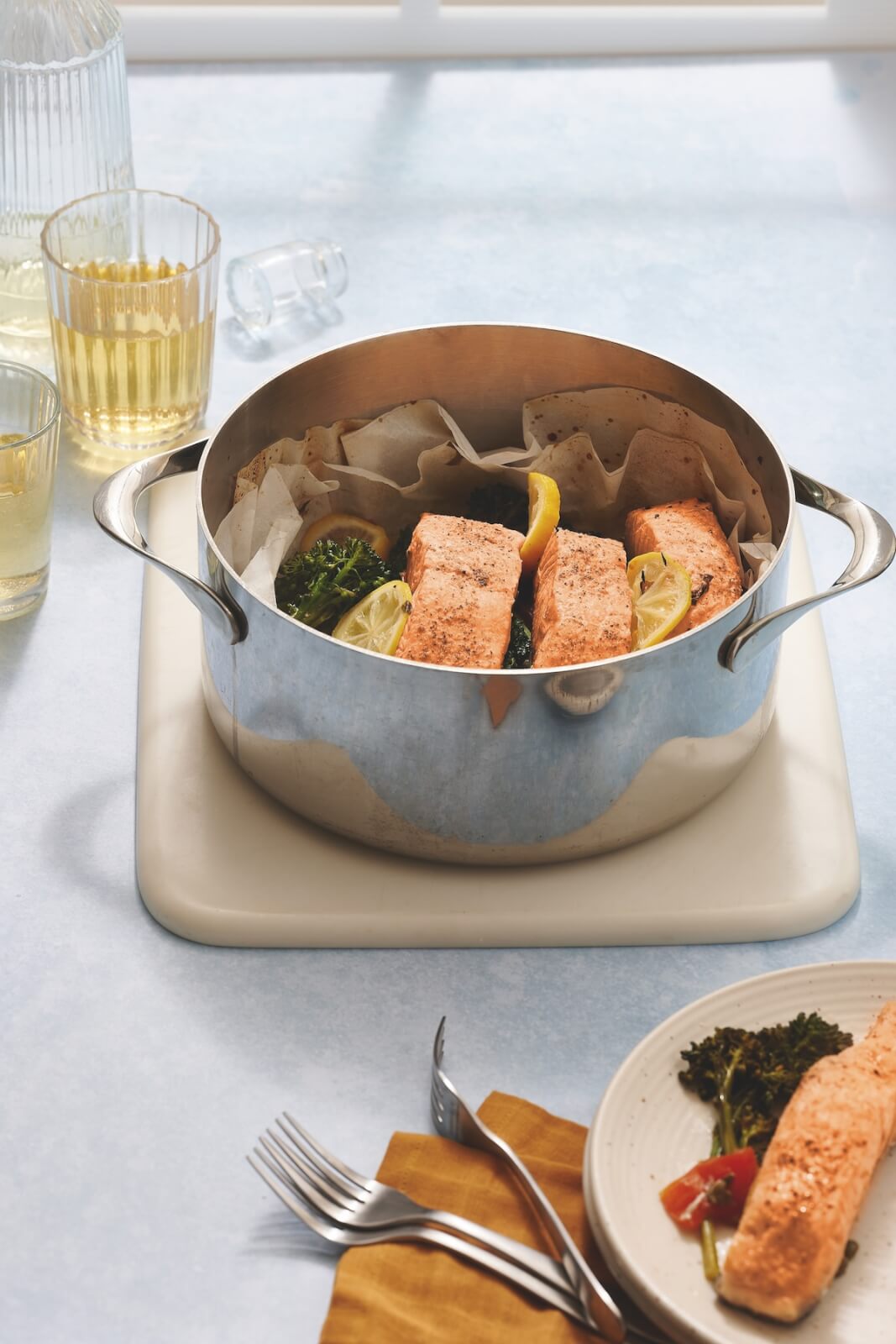 A pan with salmon and vegetables on a table.