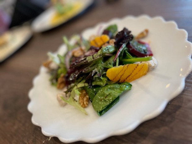 A beet salad with goat cheese, orange slices, craisins and...