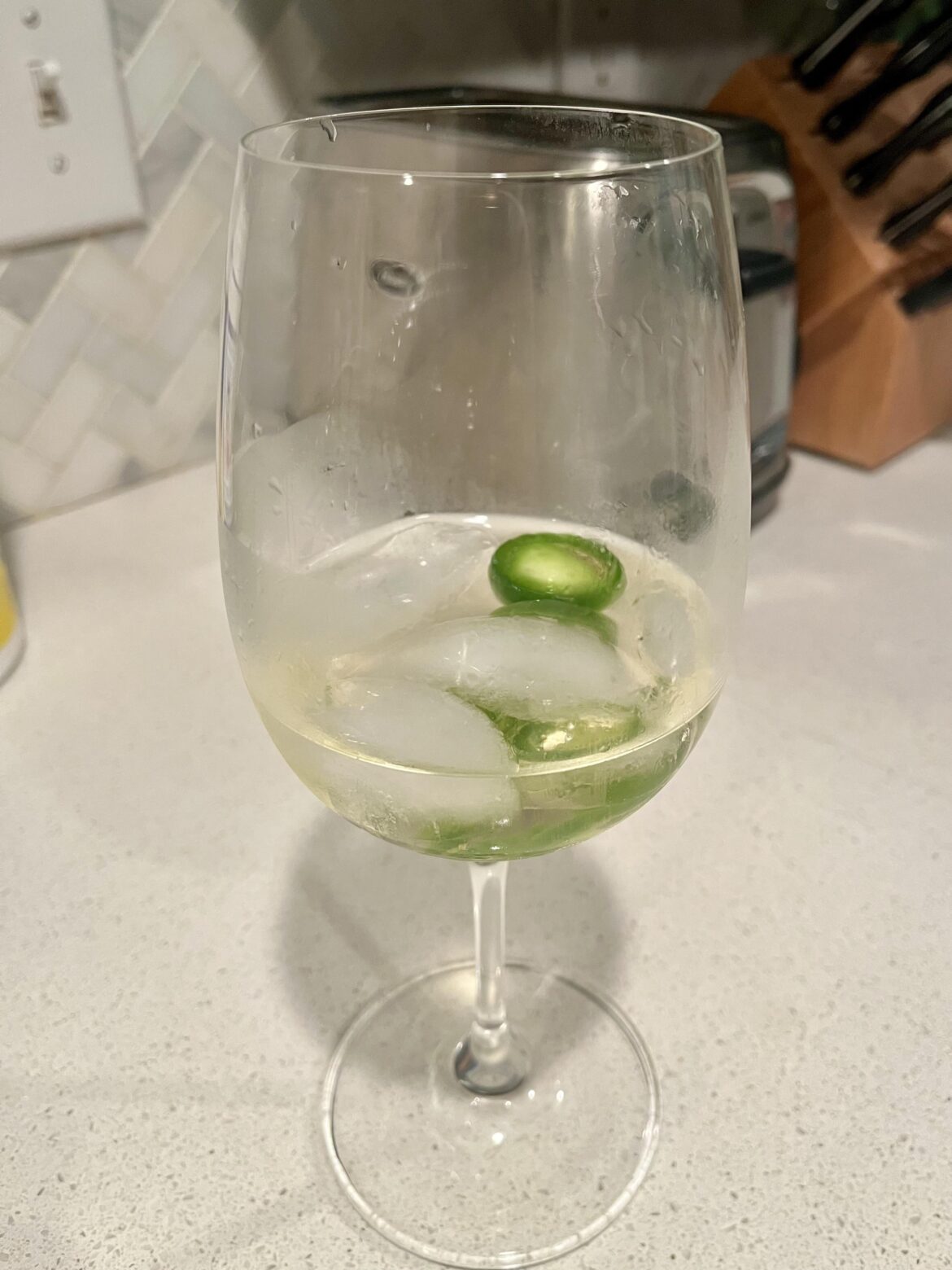 My mother drinks her white wine with ice cubes and sliced jalapeños.