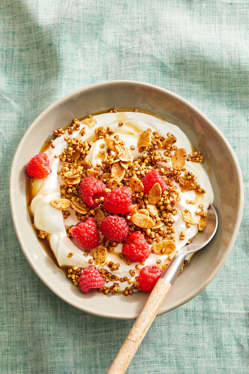 almond buckwheat granola with yogurt and berries in a bowl